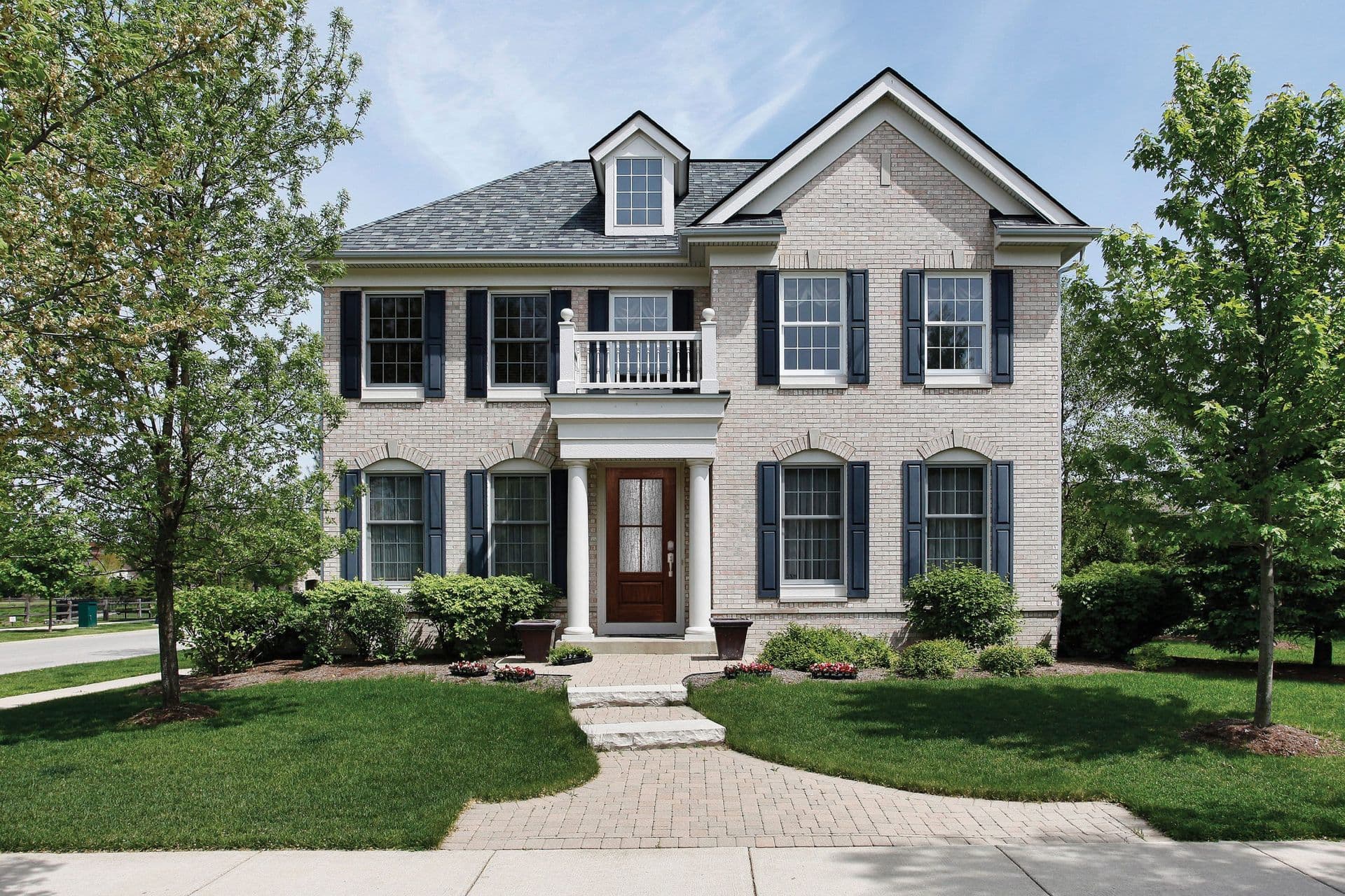 This Colonial-style home features a Timbergrain Fiberglass Exterior Door in Cherry, with a 3/4 Lite, 2 Panels door style and SDL glass, and Schlage Century hardware with Encode Deadbolt in Satin Nickel.